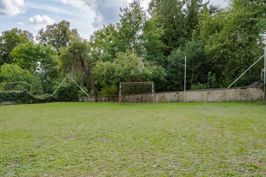 mini-football field on a lawn with a goal a little rusty in front of a wall in the region of Virton in Belgium