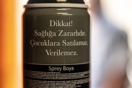 a sprey dye bottle with caution info on it with blurry background. photo has taken at izmir/turkey.