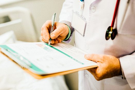 Doctor writes down health and fitness report on patients notes