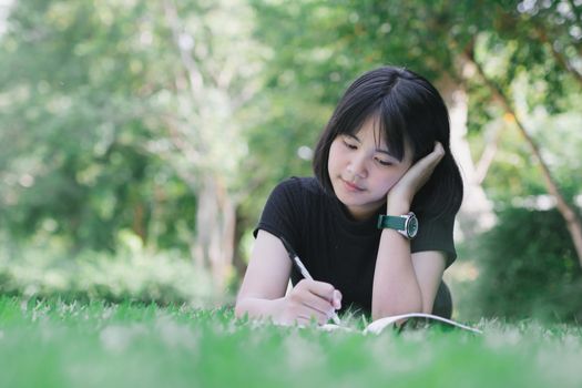 The girl is sitting in the lawn in the garden.