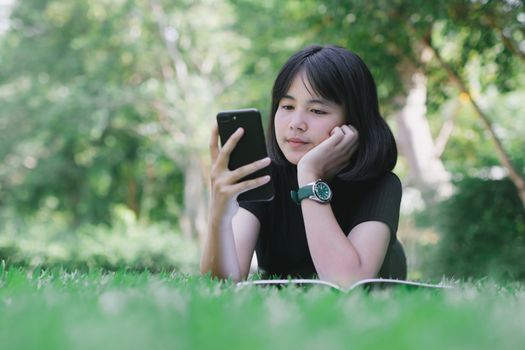 The girl is sitting in the lawn in the garden.