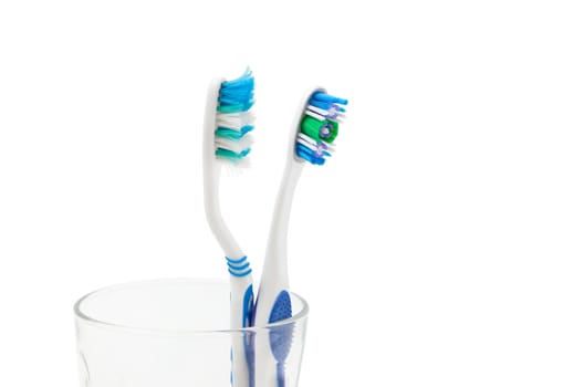 New toothbrush and old toothbrush (damaged) in clear glass for teeth cleaning isolated on white background . With clipping path
