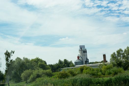 Countryside panorama blue sky with farm and silo plant in the background