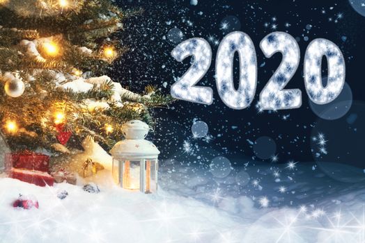 Christmas card - gifts and a lantern in the snow under a Christmas tree decorated with lights and Christmas decorations, and the inscription 2020.