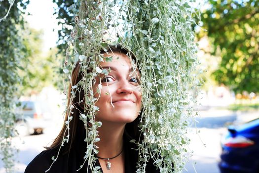 The beauty girl between long green ivy leaves