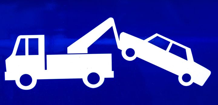 Close-up of a blue traffic sign for a suspended driver's license equal to towing and impounding, no exceptions.