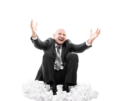 Business problems and failure at work concept - loud shouting or screaming tired stressed businessman gesturing raised hands sitting down floor on crumpled torn paper document heap white isolated
