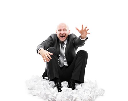 Business problems and failure at work concept - loud shouting or screaming tired stressed businessman gesturing raised hand for help sitting floor on crumpled torn paper document heap white isolated
