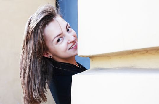 Beautiful young woman against old building wall