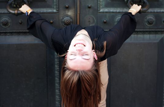 Beautiful young woman near old iron building door