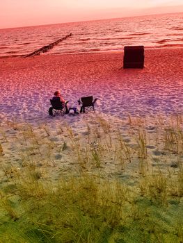Rear view of a woman on the beach in a deck chair