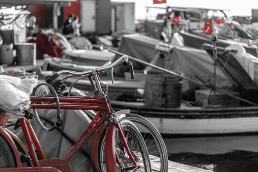 a black and white shoot from a fisherman bay - there is a red bicycle and turkish flags. photo has taken at izmir/turkey.