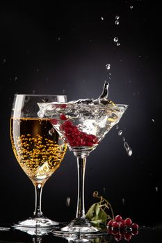 Bunch of red currant falling into the glass of water