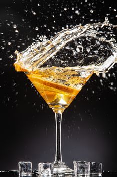 Slice of orange falling into the glass of juice