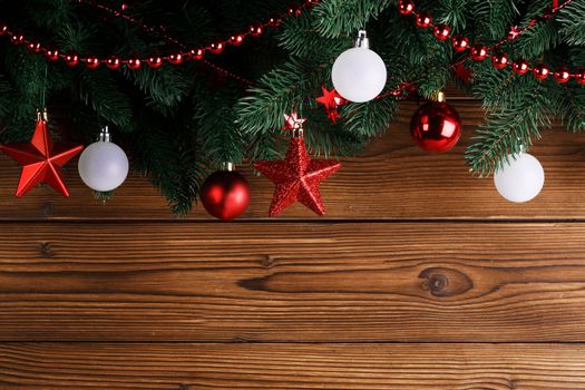 Christmas decoration frame on wooden background, fir tree branch, red and white baubles