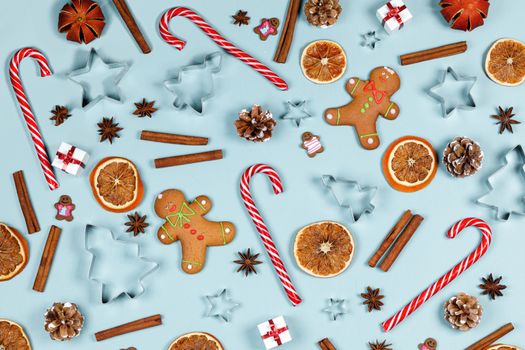 Christmas food frame. Gingerbread cookies, spices and decorations on blue background with copy space