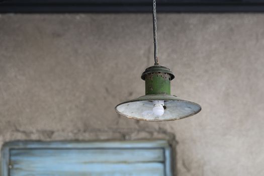 Green ancient lamp against blue stucco wall and frame as background picture
