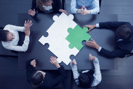 Group of business people assembling jigsaw puzzle, team support problem solution and help concept