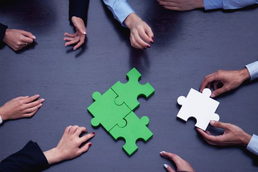 Group of business people assembling jigsaw puzzle, team support problem solution and help concept