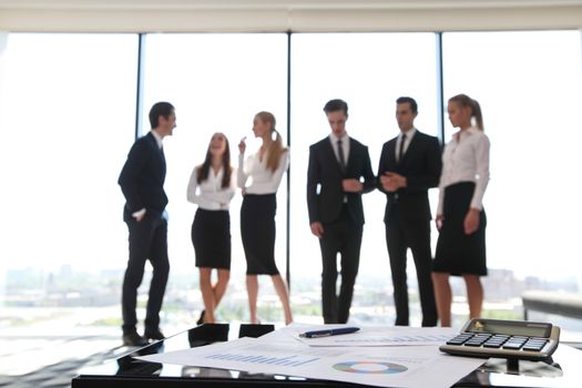Close up view of printed graphs and business people discussing financial data