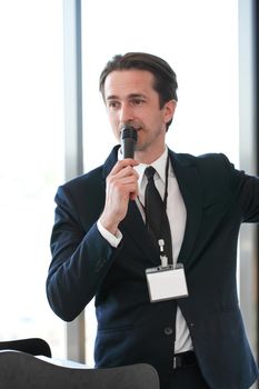 Male speaker at tribune with microphone at conference