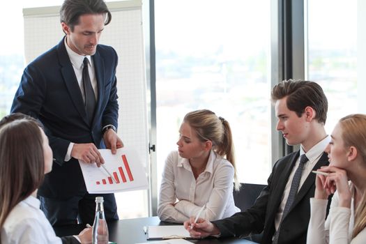 Business man showing financial statistics graph at meeting