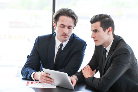 Two business men colleagues working together with tablet pc