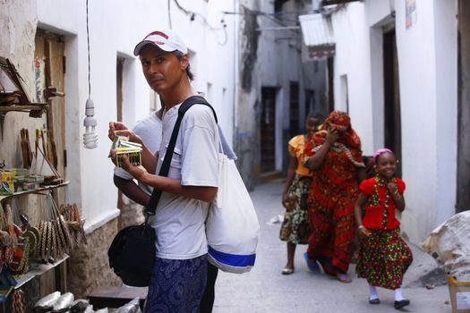 Stone Town, Tanzania - January 10, 2016: A tourist buys souvenirs on Stone Town in Tanzania