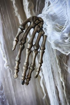Skeleton hand on the background of an old white dress