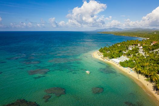 Aerial view of tropical beach with white boat anchored.Samana peninsula,Bahia Principe beach,Dominican Republic.