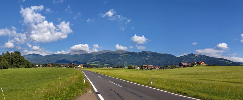 panoramic landscape of fields and Alps mountains in central Styria, Austria