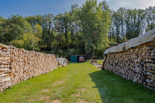 Two piles of logs stacked for drying in a meadow of Belgium, pile of logs.