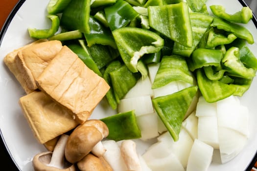 Green peppers, tofu, onion, and mushrooms in plate