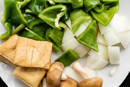 Green peppers, tofu, onion, and mushrooms in plate