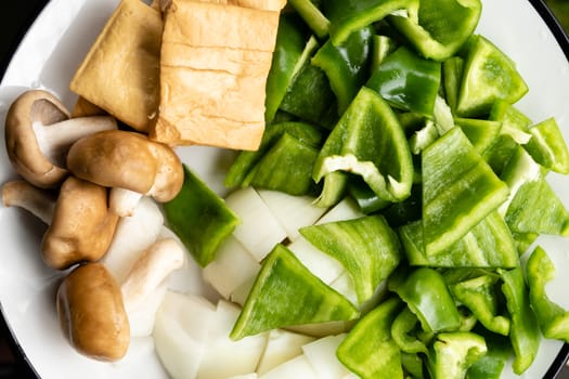 Green peppers, tofu, onion, and mushrooms in plate