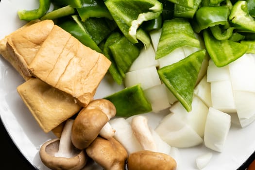 Green peppers, tofu, onion, and mushrooms in plate