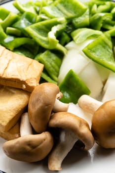 Green peppers, tofu, onion, and mushrooms in plate