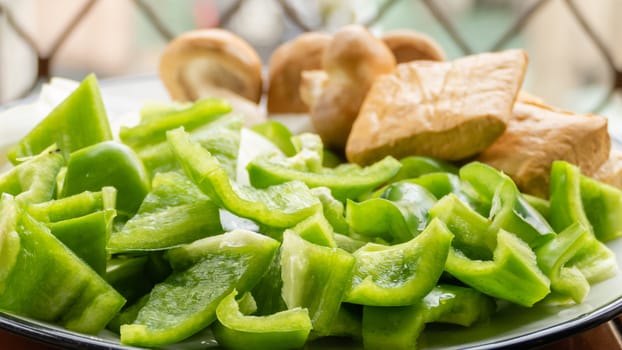 Green peppers, tofu, onion, and mushrooms in plate