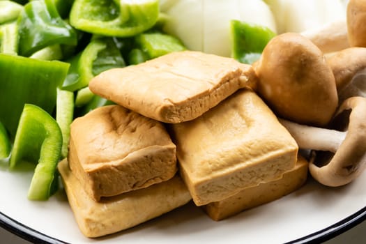 Green peppers, tofu, onion, and mushrooms in plate