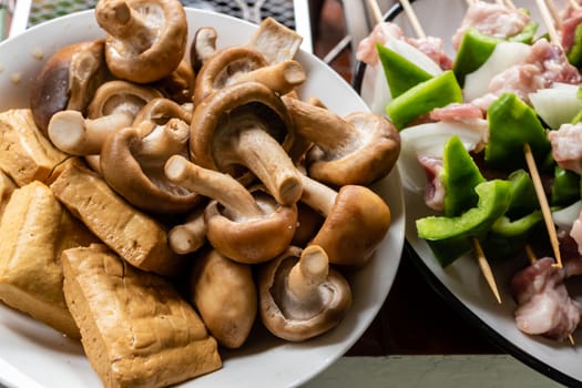 Green pepper and pork kebabs next to mushrooms and tofu