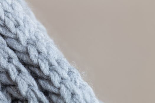 Knitted woolen textured surface on beige background. Macro. Soft grey merino wool pattern backdrop, closeup. Autumn and winter flat lay. Scandinavian minimal style. Horizontal.