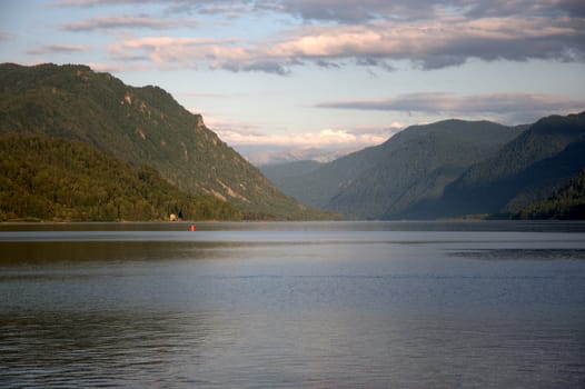 Picturesque lake surrounded by mountains at sunset. Teletskoye Lake, Altai, Siberia, Russia