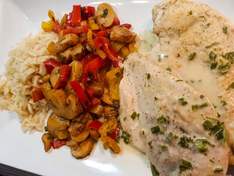 Chicken with rice and mushrooms on white plate