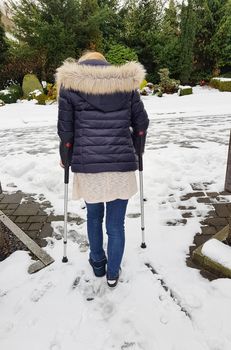 Woman walking on crutches in the park