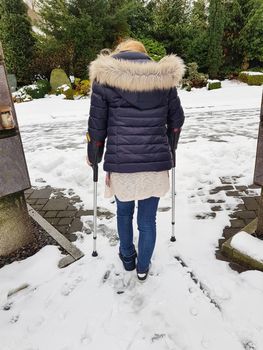 Woman walking on crutches in the park