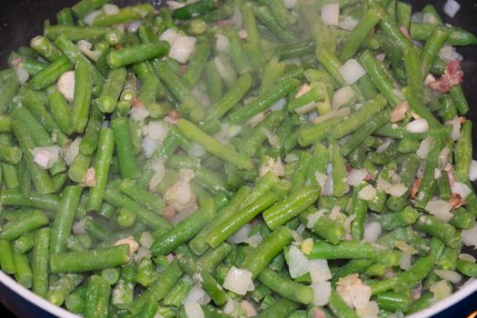 Steamed young green beans, vegetables and broccoli cooking in a pan.