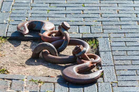 Old and rusty mooring ring for ships fixing. Dock for small boats.