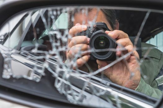 Reflection in side mirror Paparazzimannes sitting inside the car and photographing with slr camera.