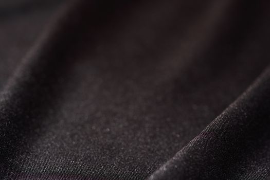 Soft black satin linen smooth textured fabric macro close-up defocused