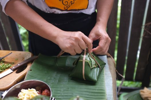 The woman use of natural materials from banana trees Used to make packaging for food. 